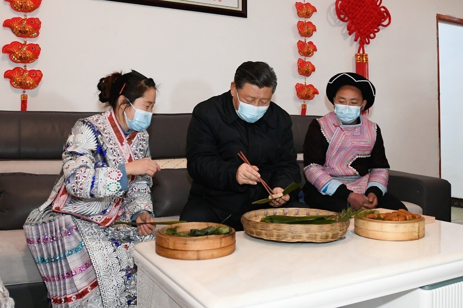 2021年2月3日下午，習(xí)近平在貴州畢節(jié)市黔西縣新仁苗族鄉(xiāng)化屋村苗族村民趙玉學(xué)家，同一家人邊聊家常邊制作當(dāng)?shù)貍鹘y(tǒng)節(jié)日食品黃粑。新華社記者 李學(xué)仁 攝