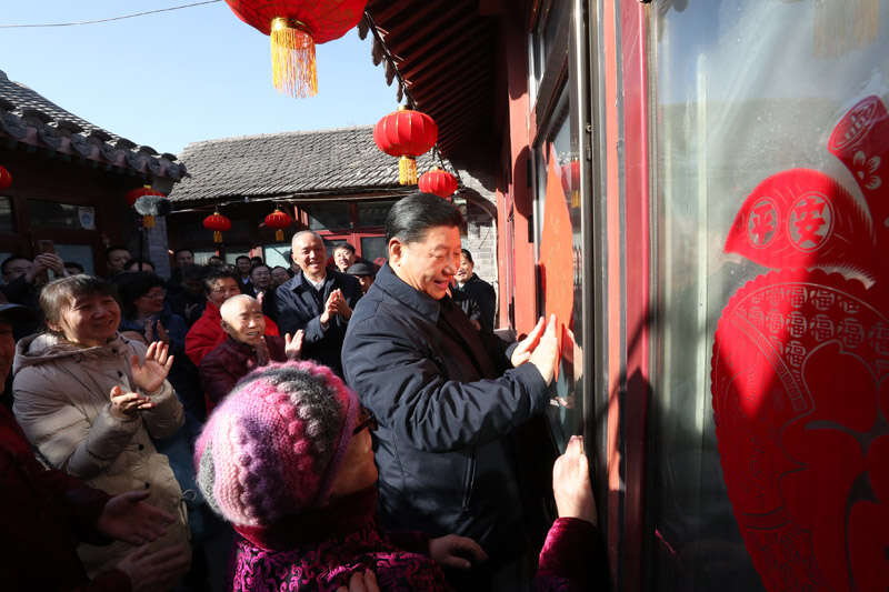 2019年2月1日上午，習(xí)近平在北京前門東區(qū)草廠四條胡同32號(hào)院，高興地拿起一幅“?！弊?，親自貼到門上，給這里的老街坊們拜年。新華社記者 鞠鵬 攝