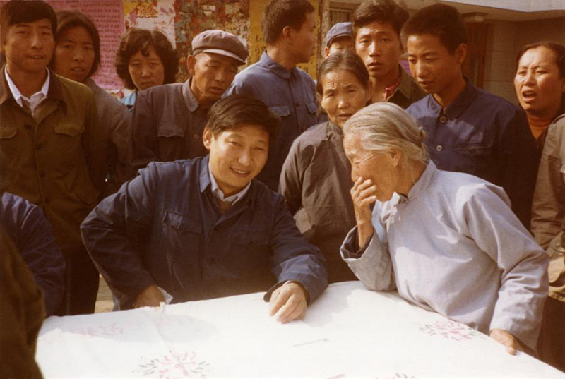 1983年，時(shí)任河北正定縣委書記的習(xí)近平（前排居中），臨時(shí)在大街上擺桌子聽取老百姓意見。
